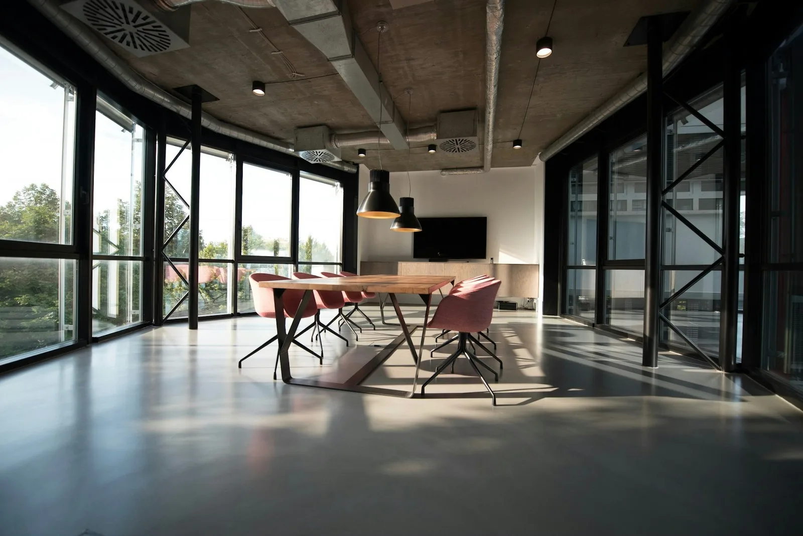 Open commercial meeting area with polished concrete floors, large windows, and daylight
